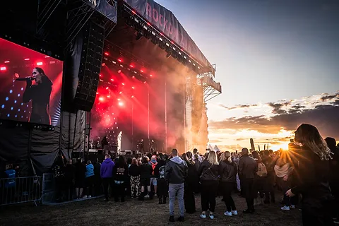 The Hardkiss – koncert plenerowy, scena z czerwonymi ekranami i publiczność o zachodzie słońca